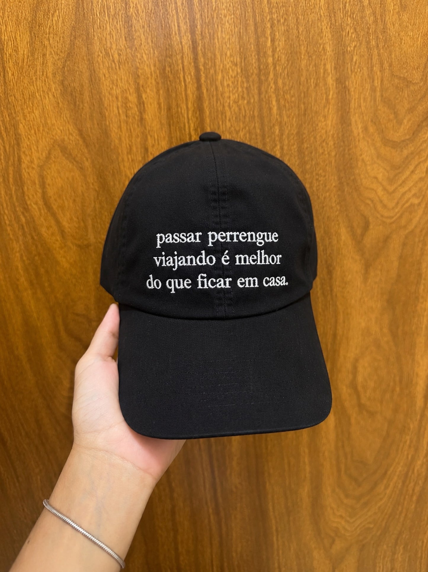 Boné Bordado com a frase "Passar perrengue viajando é melhor do que ficar em casa."
